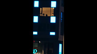 my wife topless at hotel window at night